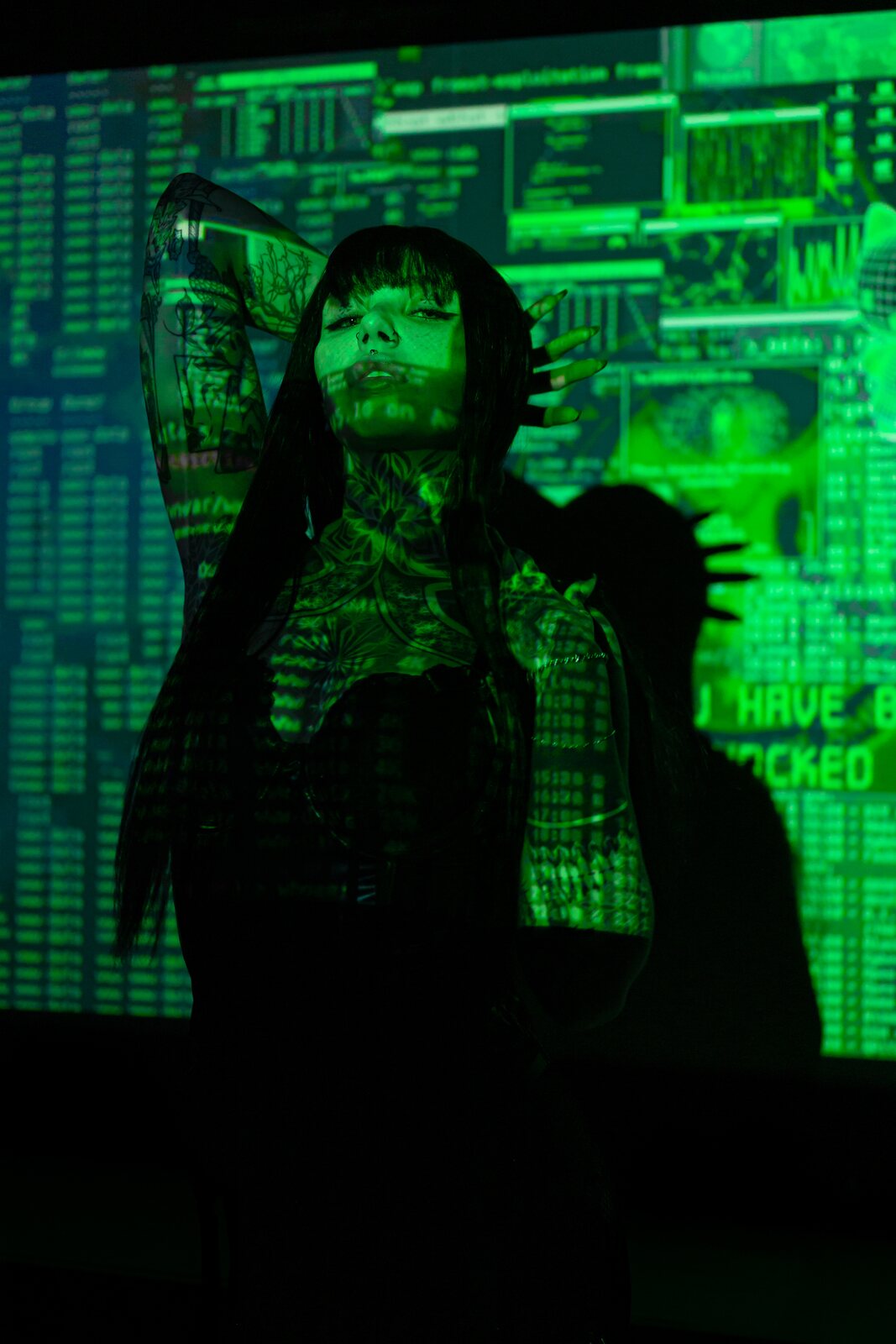 Mistress Mercy Rage under green code projection — book a session